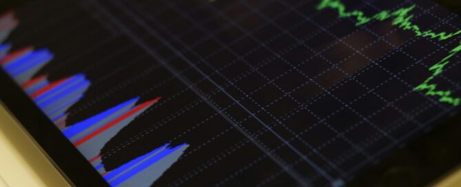 Close-up of a tablet displaying stock market analysis with colorful graphs.